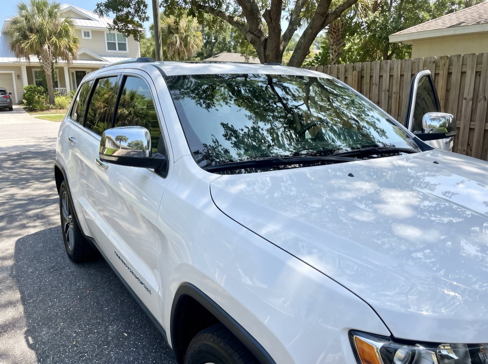 A white SUV in a driveway in Jacksonville Beach, FL, after a Bang AutoGlass mobile glass job